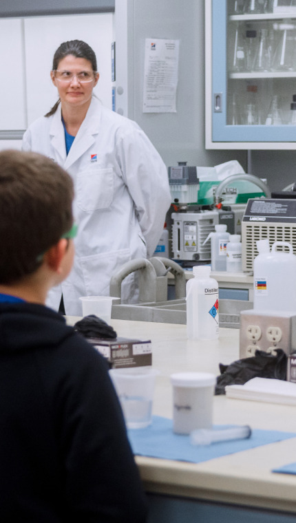 Hill's Pet Nutrition Center researcher showing the pet food lab to a group of kids